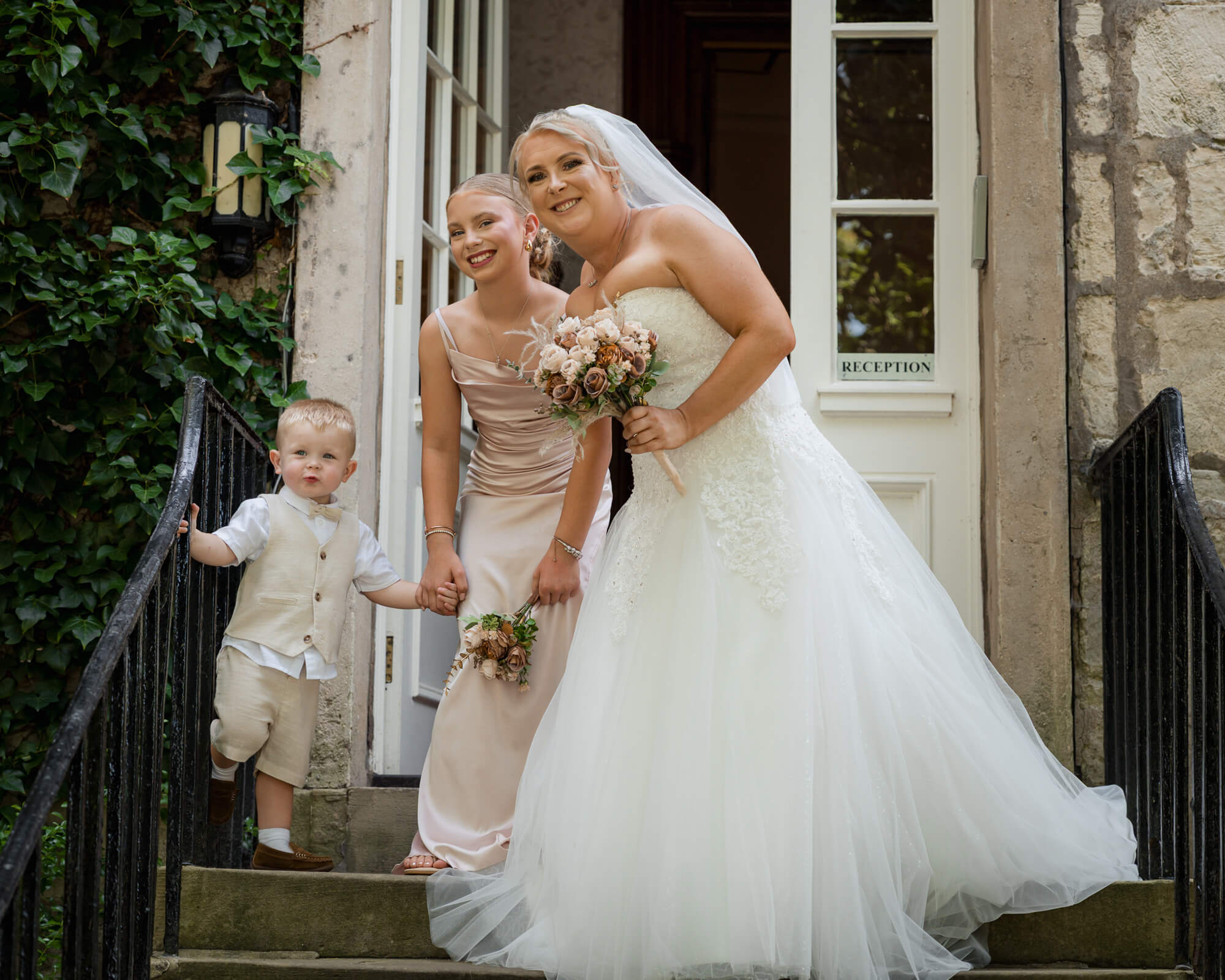 Bride with flower girl and page boy outside Hazlewood Castle.