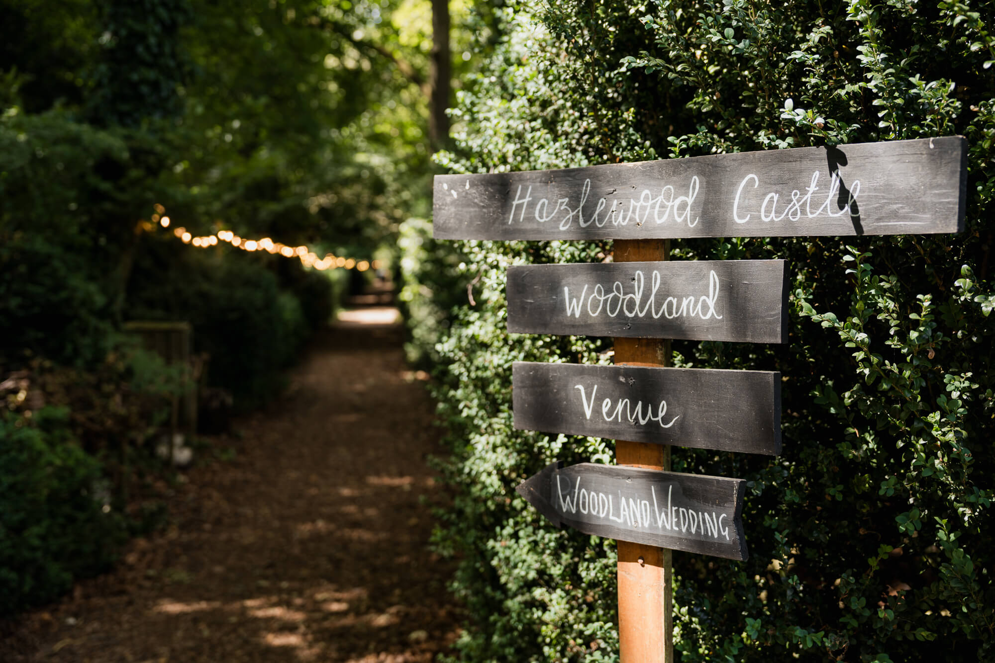Hazlewood Castle woodland wedding sign beside the ceremony path.