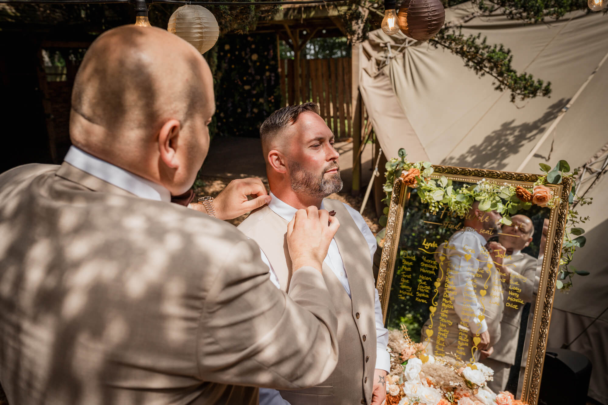 Best man adjusting the groom's bow tie before a Hazlewood Castle woodland wedding.