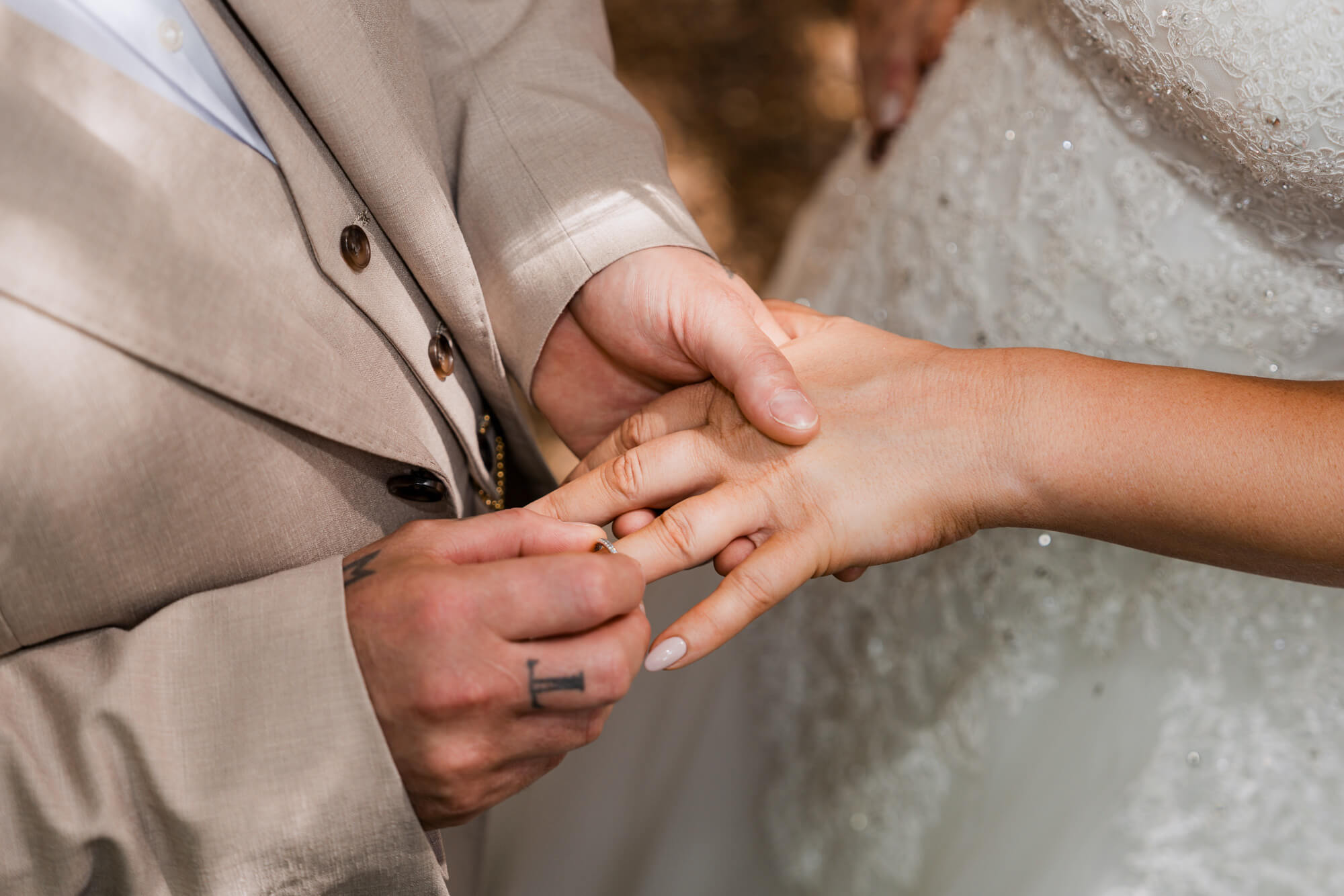 Groom placing the wedding ring onto the bride's finger.
