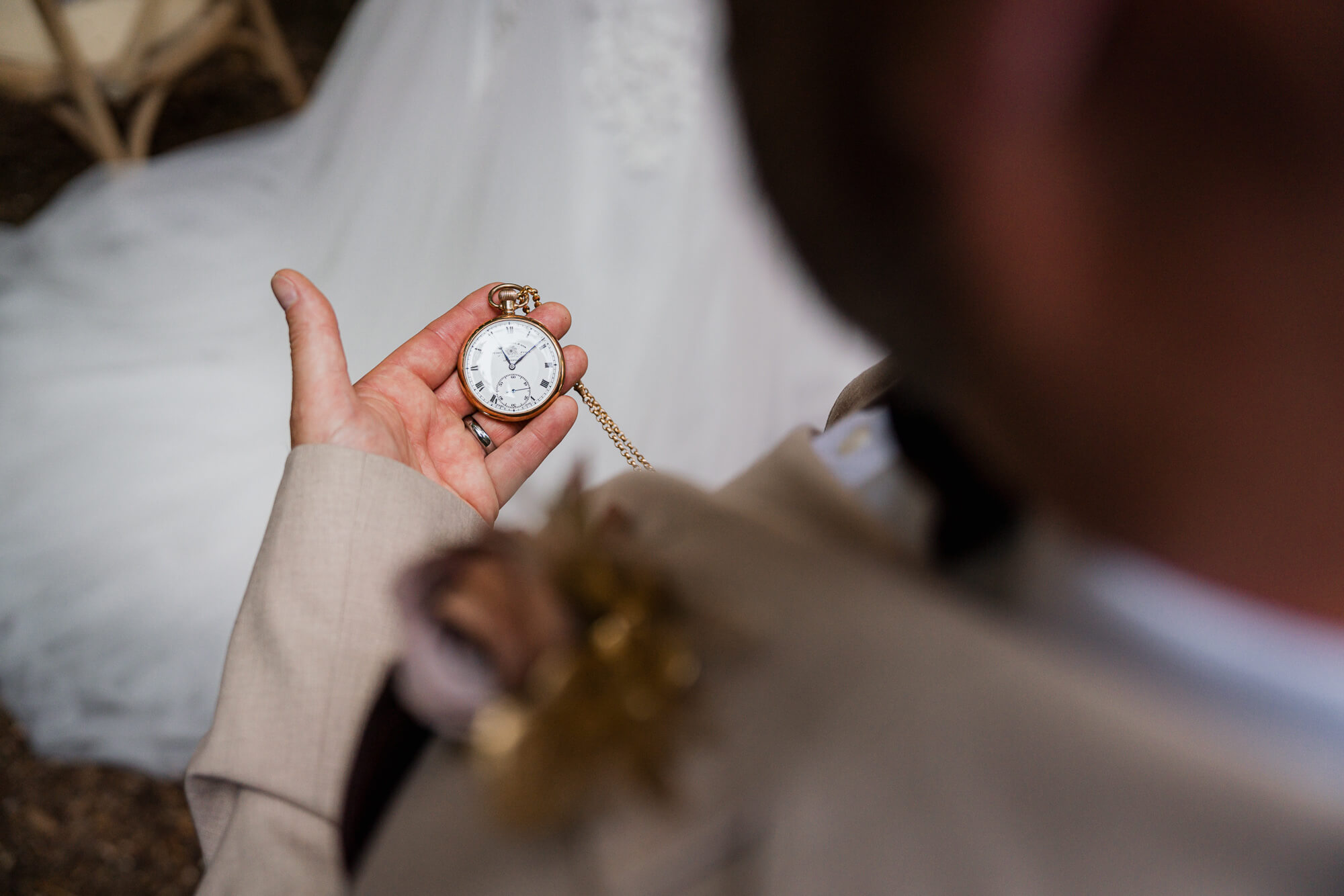 Groom holding a pocket watch before the Hazlewood Castle wedding ceremony.