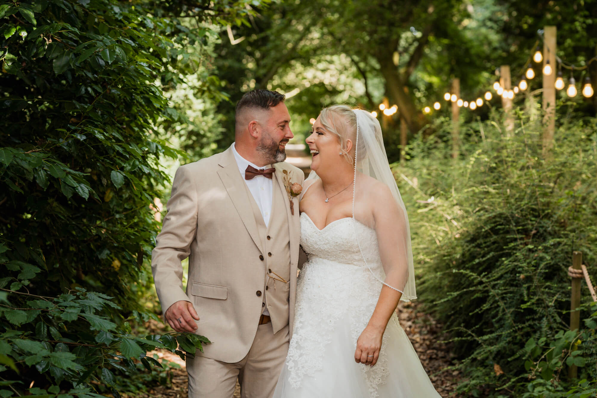 Bride and groom walking through the woodland pathway at Hazlewood Castle.