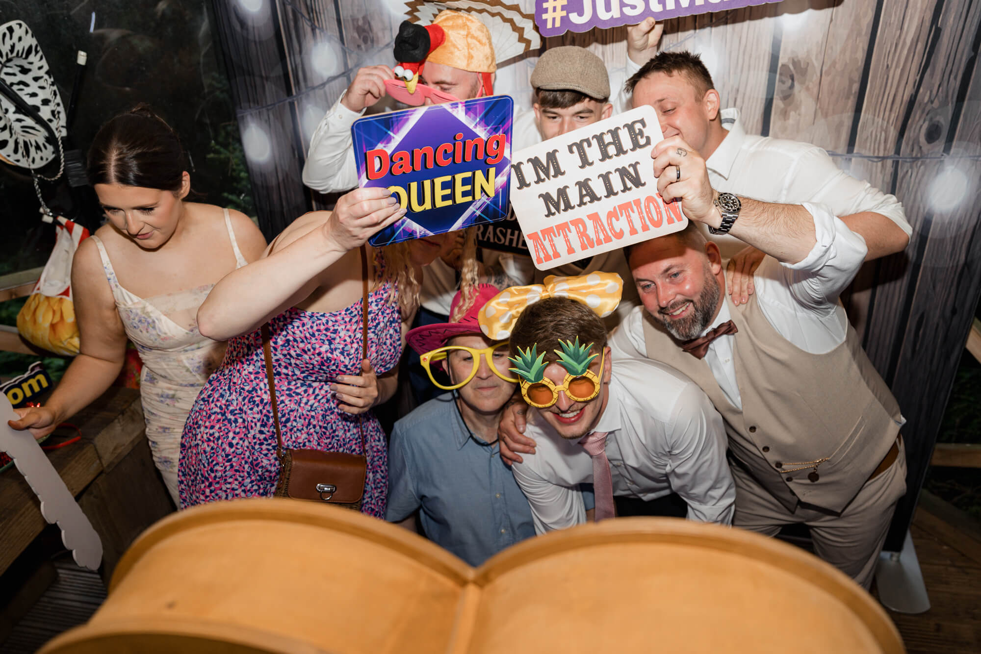Guests enjoying the wedding photobooth with fun props at Hazlewood Castle.