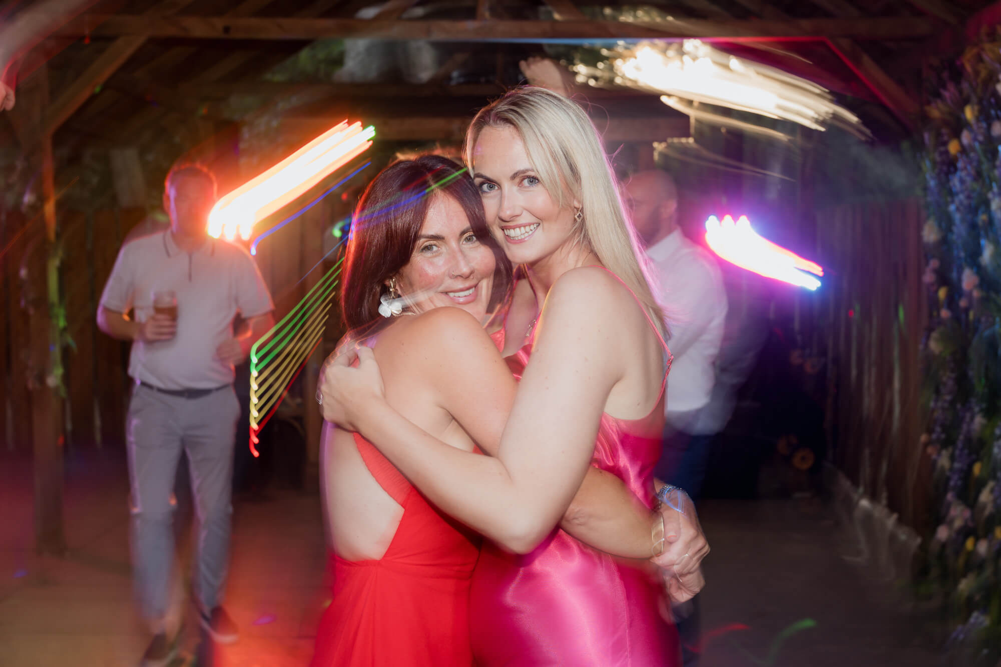 Best friends sharing a hug on the dance floor at Hazlewood Castle.