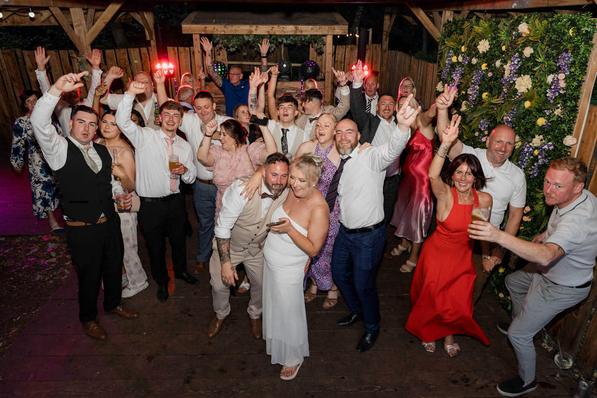 Family and friends posing together on the dance floor during the evening reception.