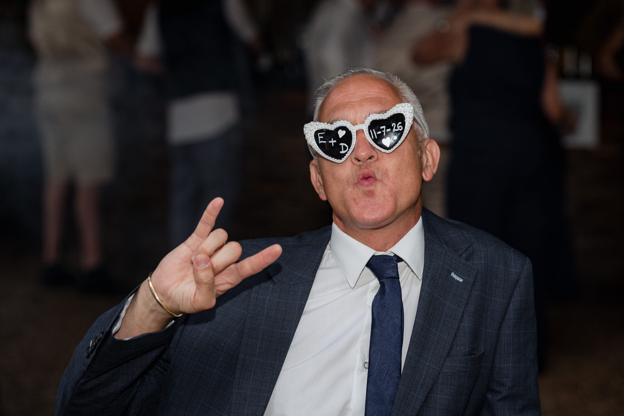 Wedding guest wearing personalised celebration glasses at Hazlewood Castle reception.