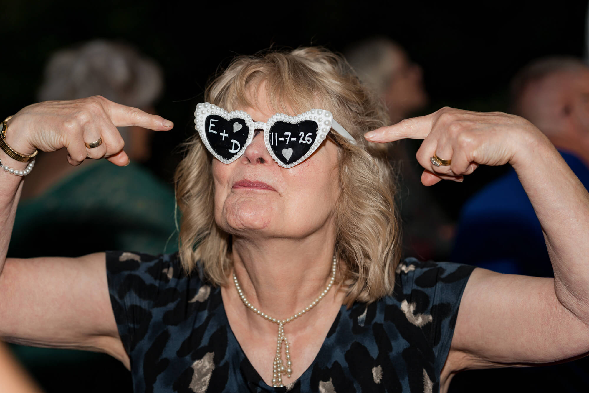 Wedding guest wearing personalised heart-shaped glasses at Hazlewood Castle.