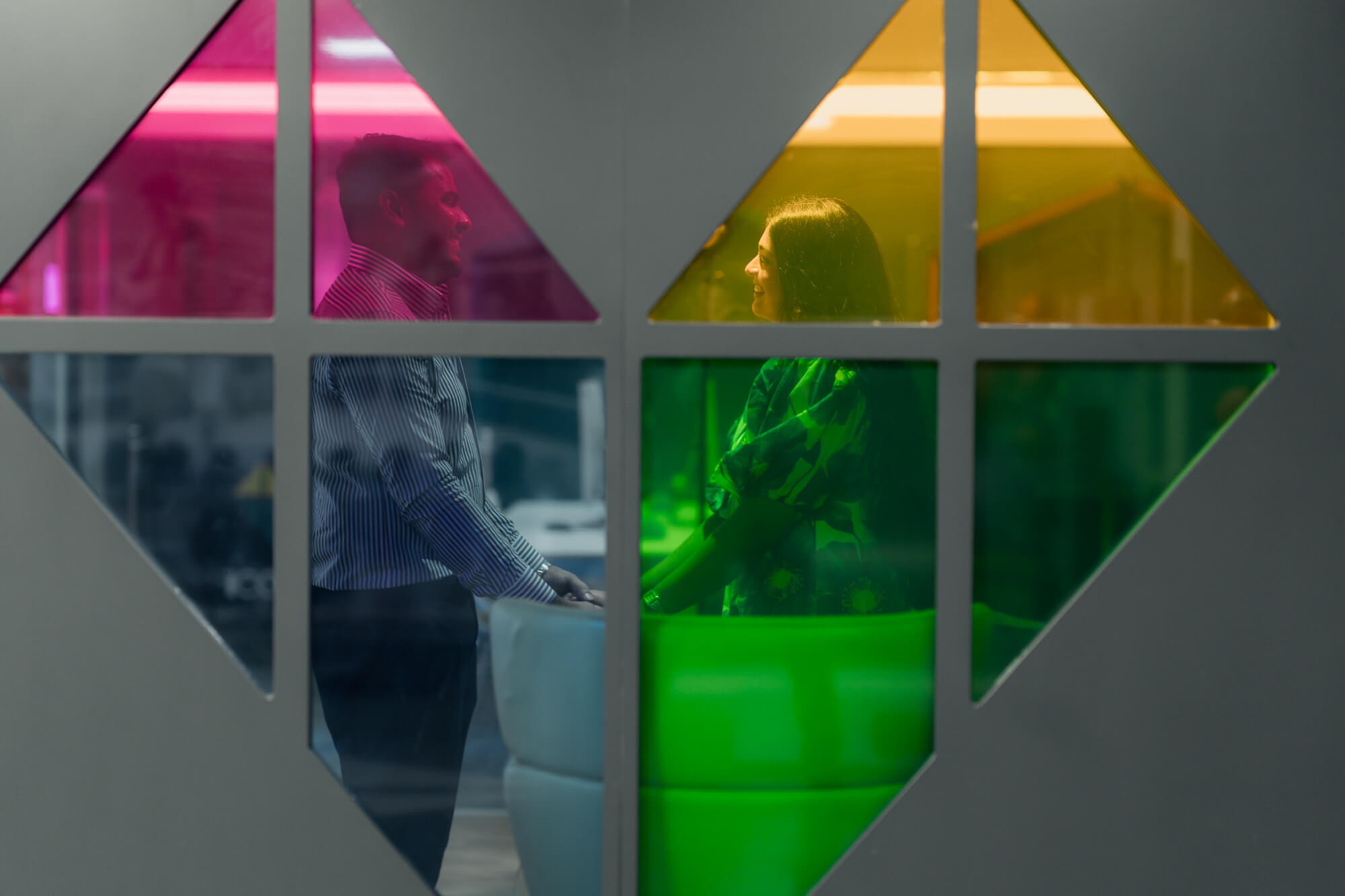 Couple framed through colourful geometric windows at Iconinc Leeds.