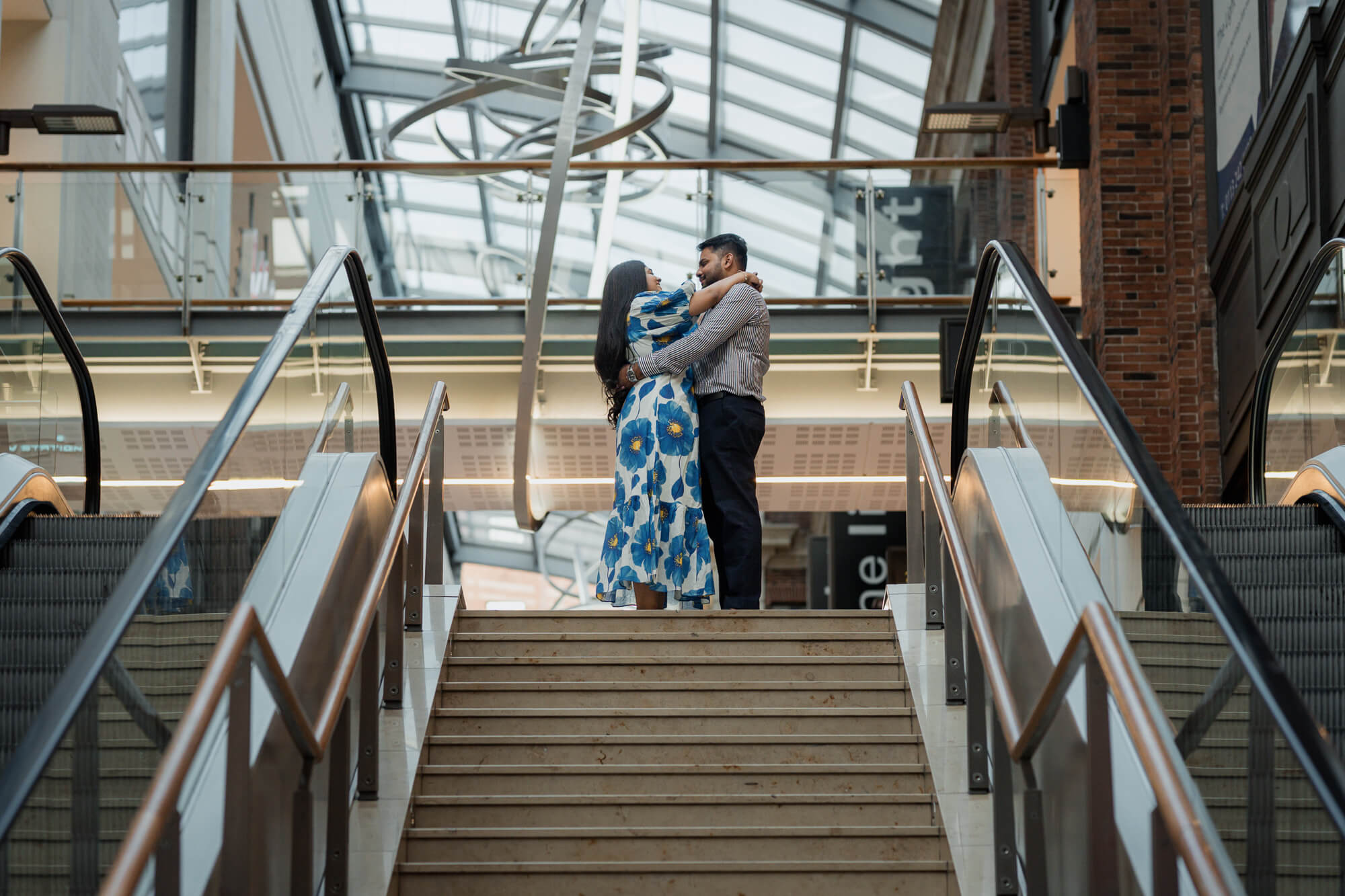 Romantic embrace at the top of an escalator during a Leeds engagement photoshoot.