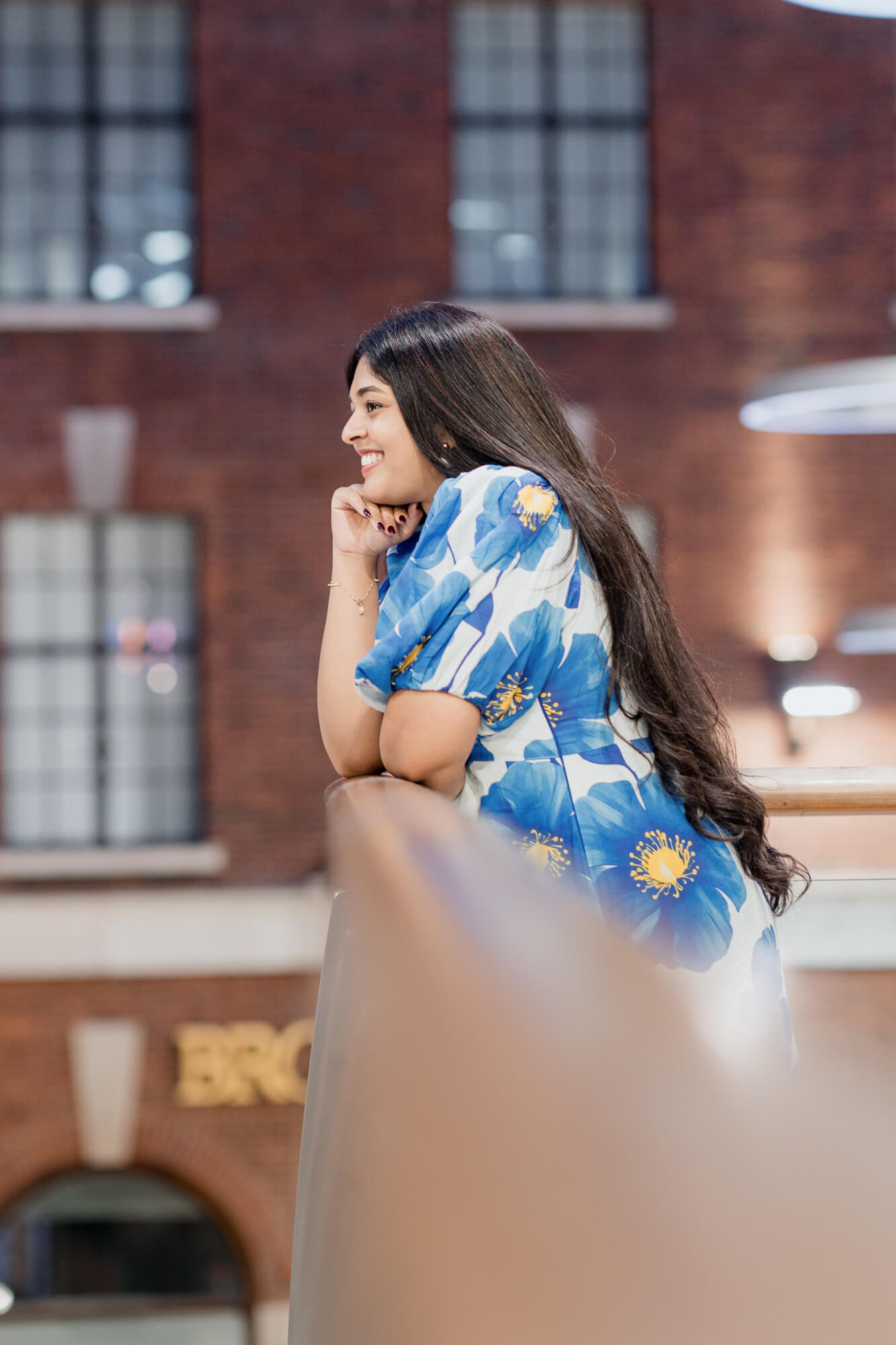 Bride-to-be smiling while leaning on a balcony during a Leeds pre-wedding photoshoot.