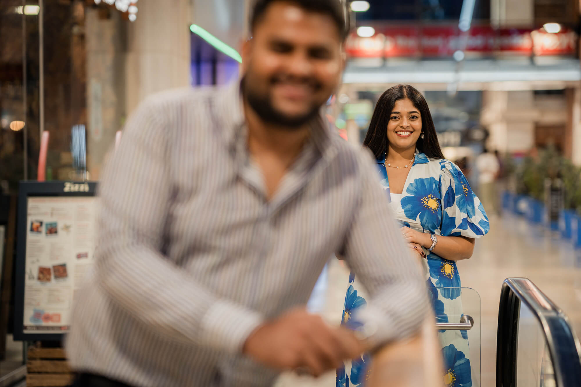 Creative engagement portrait with the bride in sharp focus and the groom artistically blurred in the foreground at The Light Leeds.