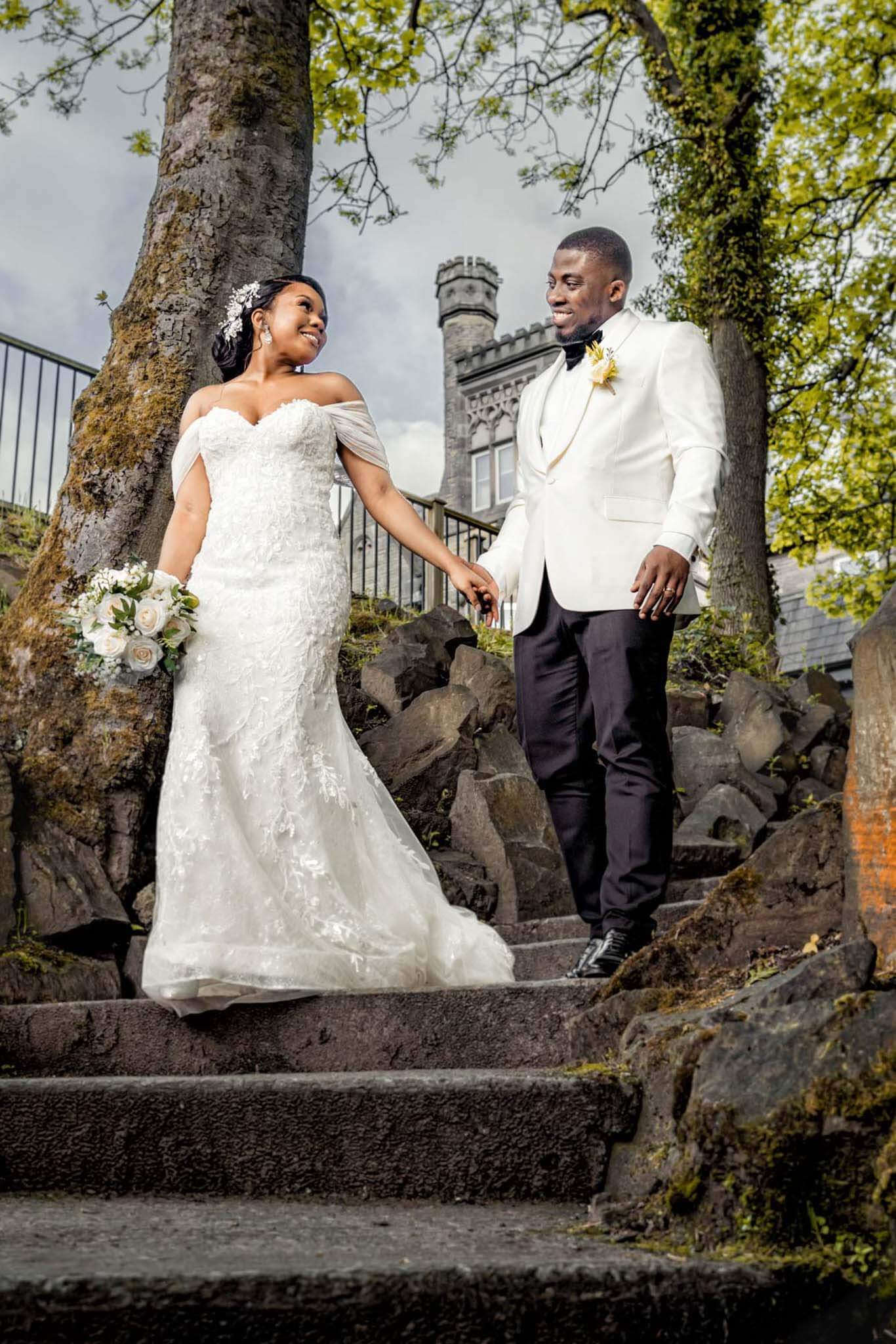 Groom and bride holding hands, while walking down the stairs . 