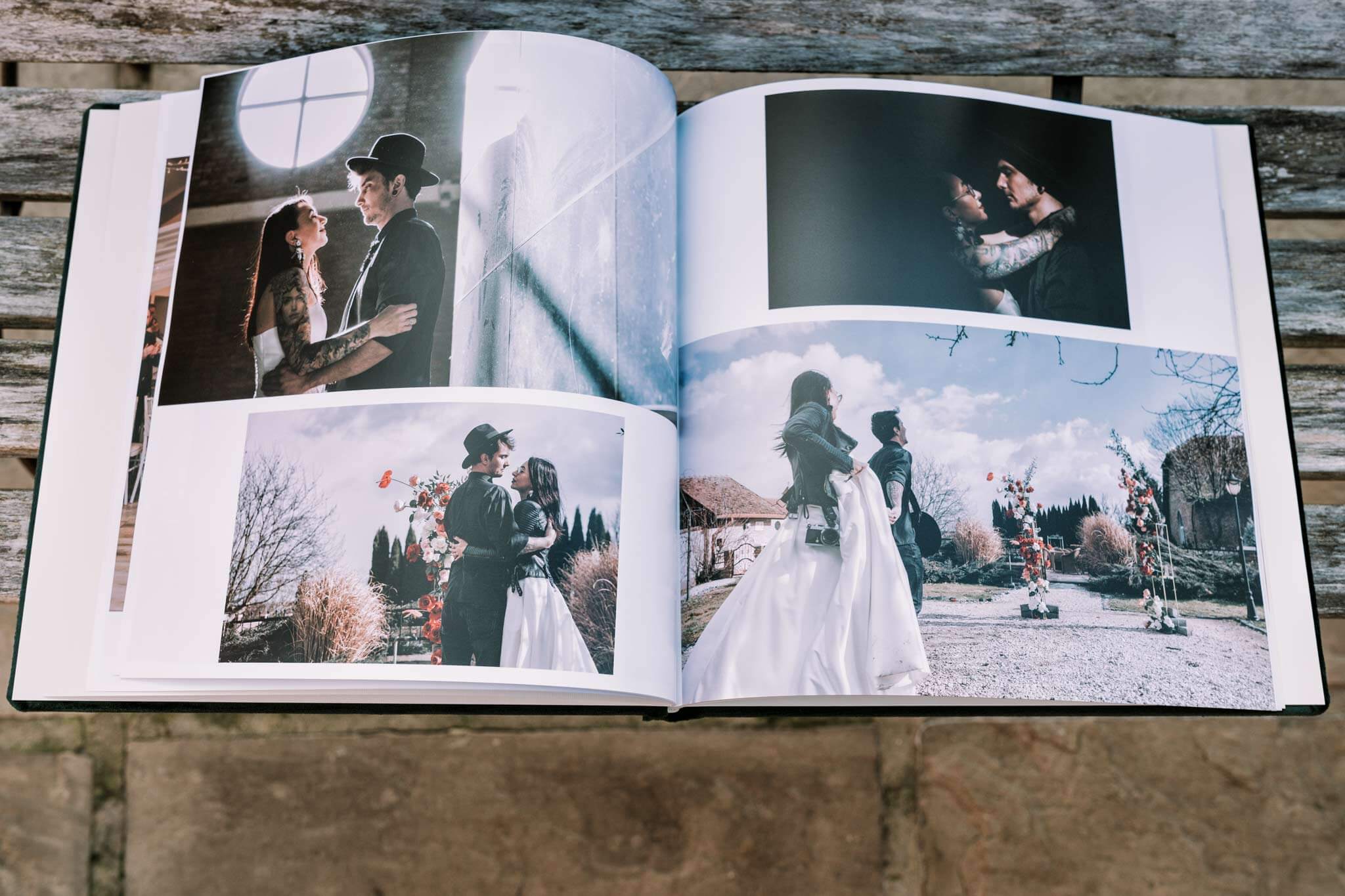 Showcasing a wedding album, with spreads open on a bench.