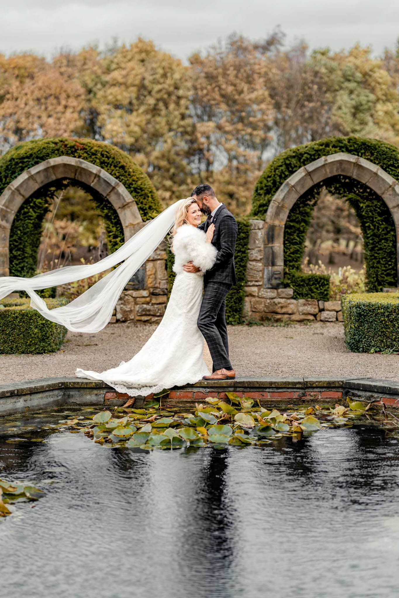 If you want to gain a average salary as a wedding photographer in the UK you need to know how to pose the couple. Groom and bride holding each into their arms at the edge of the pond, while the veil is flying in the wind.